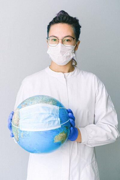 Travel First Aid Kits: Essential Items Every Traveler Needs 8 Conceptual image of a doctor holding a globe with a mask, symbolizing global health.