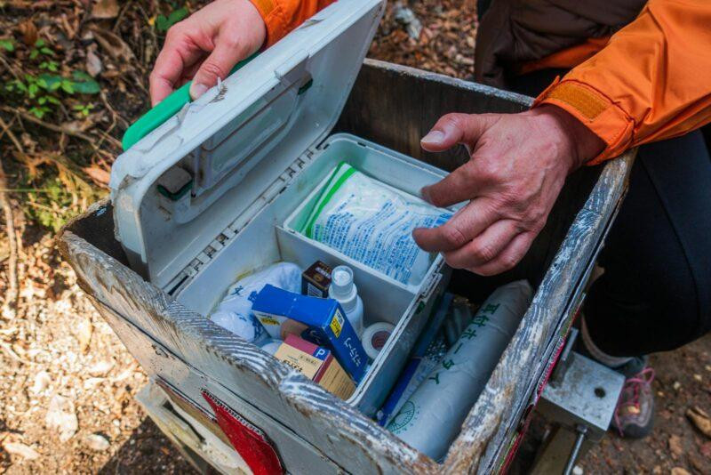 Travel First Aid Kits: Essential Items Every Traveler Needs 7 A hiker opens a first aid kit during an outdoor adventure in Dazaifu, Japan.