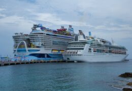 Which Cruise Line is Right For YOU? 86 Two large cruise ships docked in the scenic Bahamas, showcasing luxury sea travel.
