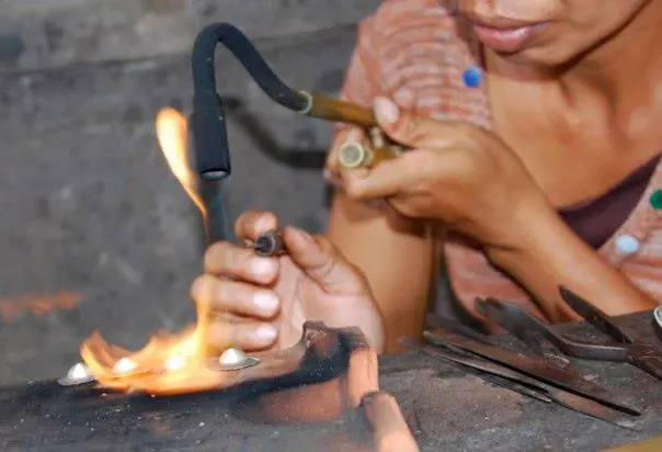 Photo of a craftswoman making jewelry