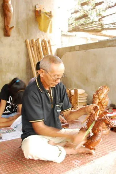 Photo of an old man polishing his sculpture