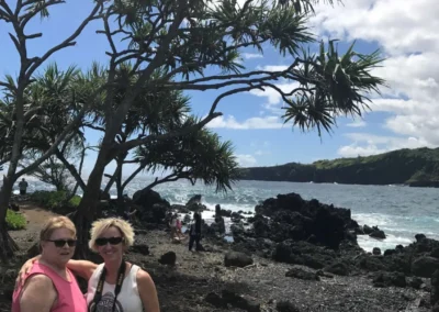 Photo of Jennifer and her mother at a beach in hawaii with black sand