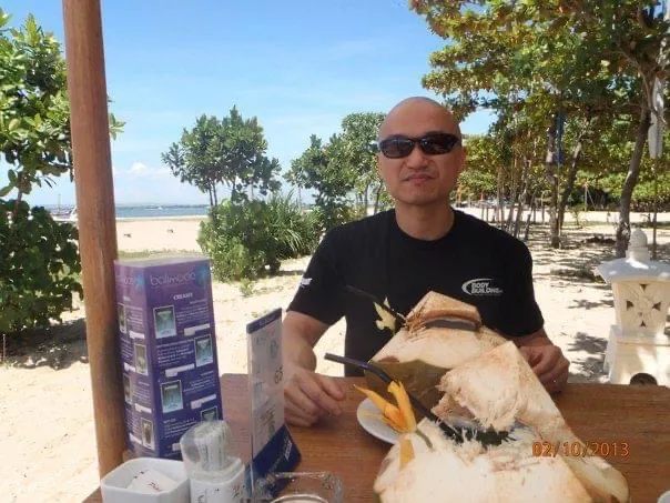 Photo of Jennifer's husband drinking coconut juice