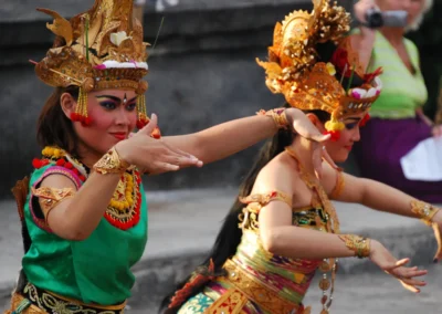 Women in colorful clothing and makeup dancing with exaggerated hand gestures