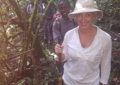 Three women and two men in forest looking for gorillas