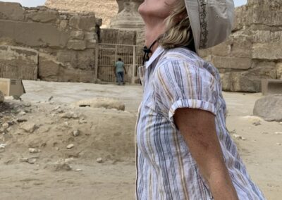 woman kissing sphinx with pyramid in background