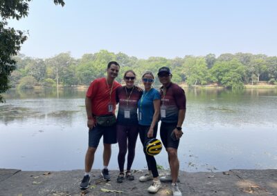 4 people standing by the water with bike helmets