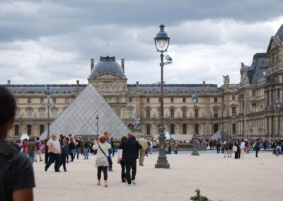 pyramid entrance to Louvre, the Louvre itself, and lots of tourists