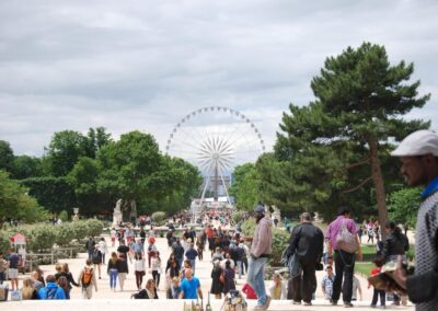 Ferris wheel with gardens and tourists in front