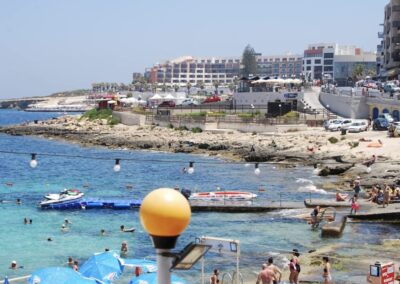 beach with coastal city and people playing