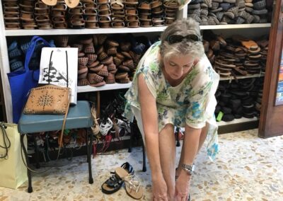 Woman trying on gold sandal with leather sole