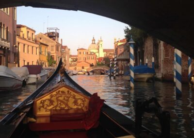 nose of gondola going under bridge with view of city