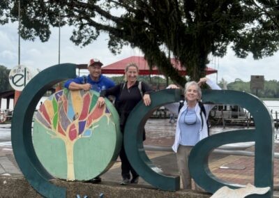 three people by Coca sign, Coca Ecuador